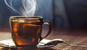 A steaming cup of herbal tea on a wooden table, representing natural remedies for pain relief and wellness.